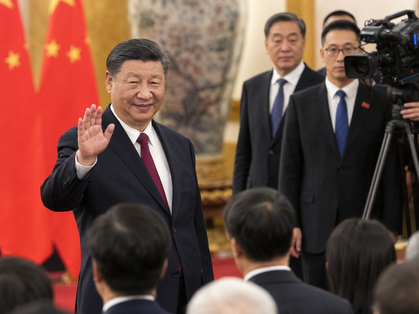 Xi Jinping saluda durante un acto oficial con banderas chinas al fondo